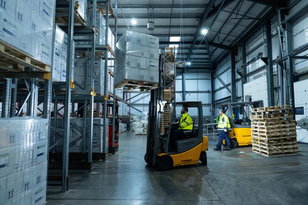 Warehouse worker driving a forklift in a storage facility
